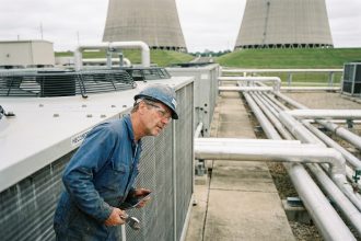 Ingénieur en overalls inspectant un condenseur industriel