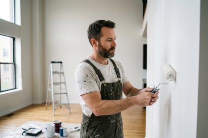 Peintre professionnel appliquant de la peinture blanche sur un mur